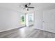 Bright bedroom featuring a ceiling fan, window, wood-look flooring, and an ensuite bathroom at 2240 Center St, Sanford, FL 32771