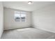 An empty bedroom with neutral walls and carpet, featuring a large window that lets in natural light at 1709 Forest Run Ln, Auburndale, FL 33823