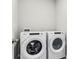 A laundry room featuring a modern, front-loading washer and dryer set with digital displays and clean, white finishes at 1709 Forest Run Ln, Auburndale, FL 33823