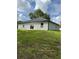 Back exterior view of a home with well-maintained lawn and a sliding glass door at 1780 Converse Ct, Deltona, FL 32738