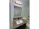 Bathroom with dark vanity, granite countertop, square mirror, and modern light fixture at 1780 Converse Ct, Deltona, FL 32738