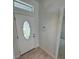 Close up on a bright foyer features decorative door and neutral tile flooring at 1780 Converse Ct, Deltona, FL 32738