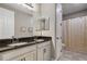Bright bathroom with a double sink vanity featuring dark countertops and white cabinets at 8300 Ludington Cir, Orlando, FL 32836