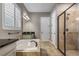 Well-lit bathroom featuring a soaking tub, walk-in shower, and double vanity with modern fixtures at 8300 Ludington Cir, Orlando, FL 32836