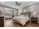 Bright bedroom featuring hardwood floors, a ceiling fan, and a sitting area with a comfortable couch at 8300 Ludington Cir, Orlando, FL 32836
