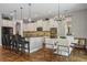 A modern kitchen features white cabinetry, sleek black countertops, and stainless steel appliances adjacent to dining area at 8300 Ludington Cir, Orlando, FL 32836