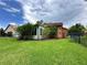 A sprawling backyard featuring a black fence, lush greenery, and an enclosed sunroom at 681 Coronado Dr, Kissimmee, FL 34759