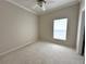 A bright bedroom with neutral walls, plush carpeting, crown molding, and a ceiling fan at 681 Coronado Dr, Kissimmee, FL 34759