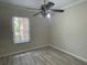 Bedroom with gray laminate flooring, ceiling fan and window at 681 Coronado Dr, Kissimmee, FL 34759