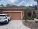 Home exterior featuring a red tile roof, brick driveway, and well-maintained landscaping at 681 Coronado Dr, Kissimmee, FL 34759