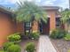 Inviting front entrance with brick walkway, palm tree, and lush landscaping at 681 Coronado Dr, Kissimmee, FL 34759