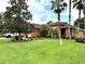 Beautiful lawn and mature trees surrounding a cozy home with a terracotta roof at 681 Coronado Dr, Kissimmee, FL 34759