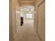Hallway leading to living room with neutral tones, arched entryway, and carpeted flooring at 681 Coronado Dr, Kissimmee, FL 34759