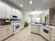 Well-equipped kitchen with white appliances, tile flooring, and plenty of counter space at 681 Coronado Dr, Kissimmee, FL 34759