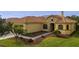 One-story house with tile roof, two-car garage, and lush landscaping at 729 San Raphael St, Kissimmee, FL 34759