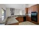 Open kitchen with granite countertops, wooden cabinets, and a breakfast bar at 729 San Raphael St, Kissimmee, FL 34759