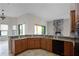 View of kitchen with granite countertops, wooden cabinets, and a stone fireplace at 729 San Raphael St, Kissimmee, FL 34759
