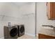 Laundry room features washer, dryer, cabinets, and granite countertop at 729 San Raphael St, Kissimmee, FL 34759