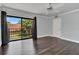 Bright bedroom with dark laminate wood floors, sliding glass doors to balcony, and ample closet space at 5263 Cypress Ct # 713, Orlando, FL 32811