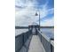 A walkway leads to a lakeside gazebo and lamp post overlooking a tranquil lake on a sunny day with scattered clouds at 3432 Westchester Square Blvd # 205, Orlando, FL 32835