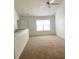 Bright loft area with large window, carpet, and white walls at 3432 Westchester Square Blvd # 205, Orlando, FL 32835