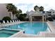 Community pool with lounge chairs and covered seating area with chairs and tables at 3432 Westchester Square Blvd # 205, Orlando, FL 32835