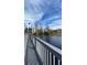 Waterfront walkway leading to community buildings with views of the lake, trees, and clear blue sky at 3432 Westchester Square Blvd # 205, Orlando, FL 32835