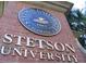 Bronze Stetson University logo on a brick wall at 531 Rhodes Dr, Deland, FL 32720