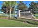 Welcoming White Heron Golf Club sign surrounded by lush landscaping and towering palm trees at 333 Navarra Ln, Davenport, FL 33837