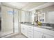 Elegant bathroom featuring double vanity, granite countertops, and a glass-enclosed shower at 2288 Sirena Ln, Mount Dora, FL 32757