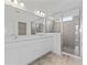 Bright bathroom with double vanity, quartz counters, and frameless glass shower at 2288 Sirena Ln, Mount Dora, FL 32757