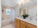 Well-lit bathroom features double sinks, neutral tile and bathtub with shower at 65 Keeble Ave, Debary, FL 32713