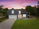 Charming two-story home featuring a well-manicured lawn, a two-car garage, and beautiful landscaping at 65 Keeble Ave, Debary, FL 32713