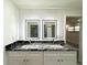 Elegant bathroom featuring dual sinks, granite countertops, and illuminated mirrors at 4808 Anderson Rd, Orlando, FL 32812