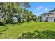 Expansive backyard with lush green grass, mature trees, and view of the lake at 9 Stone Gate N, Longwood, FL 32779