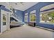 Expansive bedroom with blue walls, large windows offering serene views, and unique architectural details at 9 Stone Gate N, Longwood, FL 32779