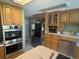 Bright kitchen featuring wooden cabinetry, stainless steel appliances, and a large island perfect for meal preparation at 9 Stone Gate N, Longwood, FL 32779