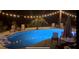 Inviting backyard pool area with ample seating and decorative string lights at night at 9 Stone Gate N, Longwood, FL 32779