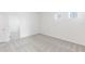 Bright bedroom featuring neutral carpet and walls with a view to a second bedroom and windows at 3054 Suraj Cir, Tavares, FL 32778