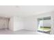 Open concept living room with large windows and tiled flooring, leading to the entryway and stairway at 3054 Suraj Cir, Tavares, FL 32778