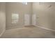 Spacious living room with neutral carpet, window and two doors at 889 Park Grove Ct, Orlando, FL 32828