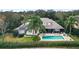 Home with pool and patio, surrounded by lush landscaping and a fenced backyard at 25515 Hawks Run Ln, Sorrento, FL 32776