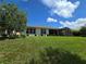 Spacious backyard with lush green grass, mature trees, and a screened patio for relaxation and entertainment at 840 Jasmine Creek Rd, Kissimmee, FL 34759