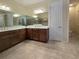 A bathroom with double sinks, a large mirror, and a tiled shower at 840 Jasmine Creek Rd, Kissimmee, FL 34759