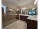 This bathroom showcases a frameless shower, double vanity, and decorative wall tiles at 840 Jasmine Creek Rd, Kissimmee, FL 34759