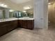 Bathroom with double sink vanity, white countertops, large mirrors, and ample storage space at 840 Jasmine Creek Rd, Kissimmee, FL 34759