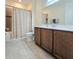 Bathroom featuring a tub with shower and vanity with white countertop and brown cabinets at 840 Jasmine Creek Rd, Kissimmee, FL 34759