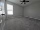 A carpeted bedroom that features neutral walls, a ceiling fan, and natural light from the window at 840 Jasmine Creek Rd, Kissimmee, FL 34759