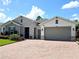 House exterior view, featuring a gray and stone facade with a two-car garage at 840 Jasmine Creek Rd, Kissimmee, FL 34759