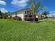 Well-manicured front lawn featuring lush grass and a variety of decorative plants and shrubs at 840 Jasmine Creek Rd, Kissimmee, FL 34759